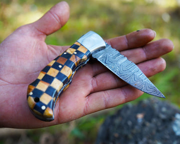 Artisan Damascus knife with patterned blade on user hand size comparison